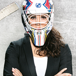 Hockeymålvaktsmask bredvid kostym på hängare